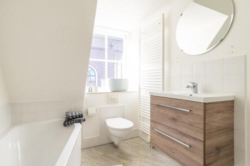 霍勒姆Herenweg Apartments的一间带卫生间、水槽和镜子的浴室