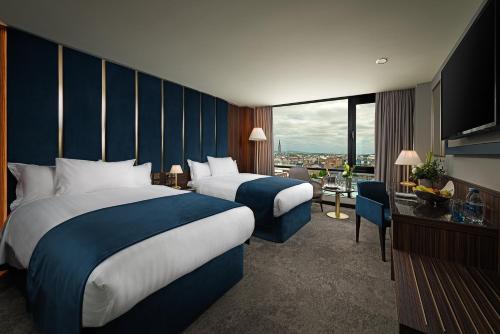 利默里克萨弗伊酒店的酒店客房设有两张床和大窗户。
