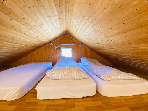 埃基斯蒂尔Ábót - Riverside Cottage的配有木天花板的客房内的两张床