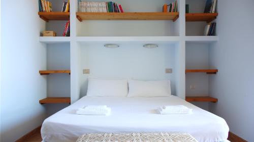 托里格兰德Welcomely - Sardinian Stone House的卧室配有带书架的白色床