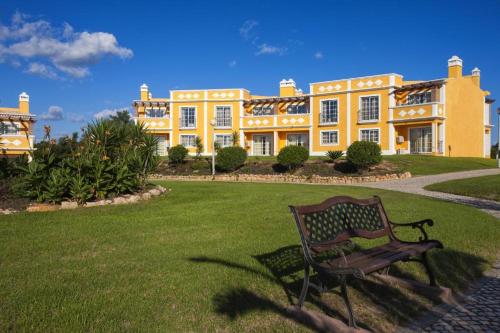 卡武埃鲁Colina da Lapa & Villas的黄色大建筑前面的长凳