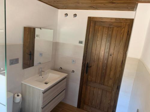 波索阿尔孔Casa Rural Las Nueces的一间带水槽和木门的浴室