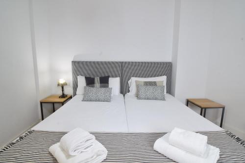 马拉加Letmalaga Premium Malagueta的卧室配有一张带两个枕头的大白色床