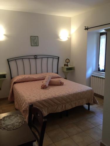 佩斯卡塞罗利Albergo Andromeda的一间卧室配有一张带粉红色床罩的床