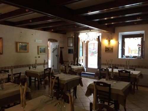 佩斯卡塞罗利Albergo Andromeda的一间在房间内配有桌椅的餐厅