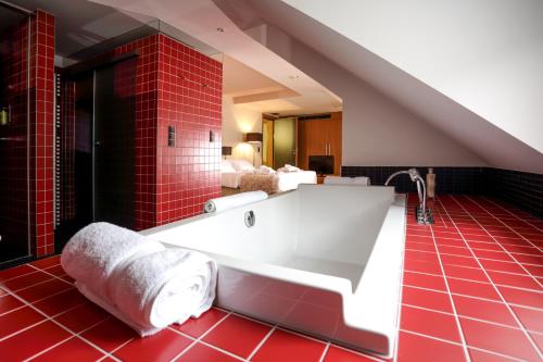 蒙多夫莱班安克劳史特酒店的浴室设有红色瓷砖的大浴缸