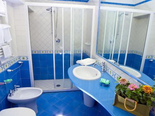 伊斯基亚安巴夏托里酒店的蓝色的浴室设有水槽和淋浴