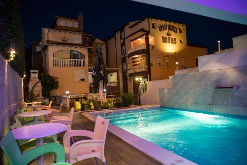 莫斯塔尔维拉纳丁酒店的一座带桌椅的游泳池位于大楼旁