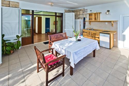 赫瓦尔Apartments Villa Marcelina的厨房配有桌子和两把椅子、一张桌子,厨房