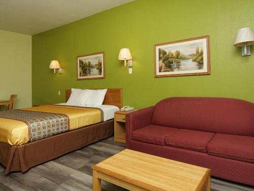 韦瑟福德唯佳汽车旅馆的酒店客房,配有床和沙发