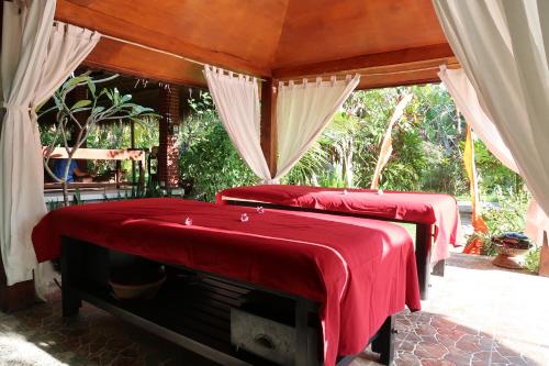 特贾库拉Villa Aditya的宿舍间的两张床,上面有红色的盖子
