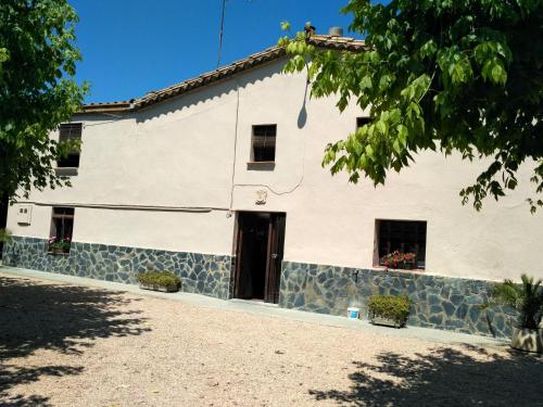 维罗维-德欧纳Casa Rural "Can Abres" Vilobi d`Onyar Girona的白色的建筑,设有黑色的门和窗户