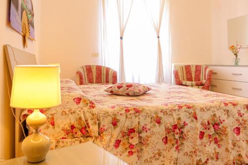伊斯基亚Mini Hotel Rendez Vous的一间卧室配有一张带鲜花毯子和灯的床。