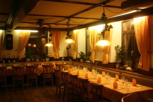 Bötzingen太阳乡村酒店的用餐室配有桌椅和灯光