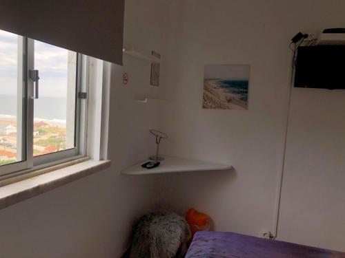 卡帕里卡海岸Fonte da Telha Beach Hostel的一间卧室设有一张床和一个窗口