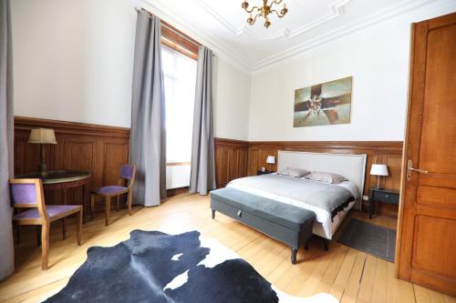 拉翁莱塔普Gite Logis des Fontaines的一间卧室配有一张床、一张桌子和一个窗户。