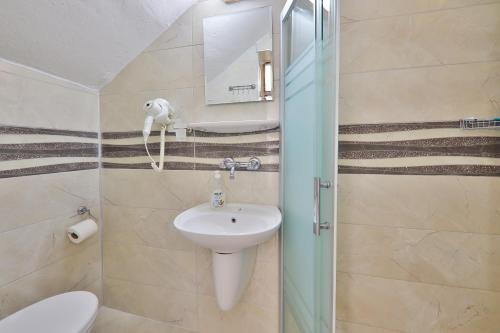 卡斯圣淘沙膳食旅馆的一间带水槽、卫生间和镜子的浴室