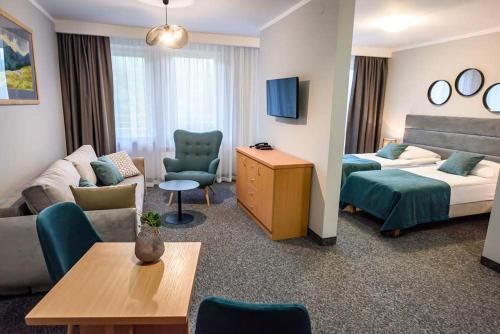 克雷尼察加里西亚培训和度假酒店的酒店客房设有床和客厅。