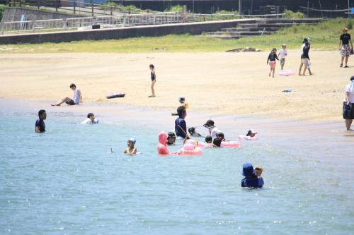 志摩市鲸望庄海滨旅馆的一群人,在海滩上