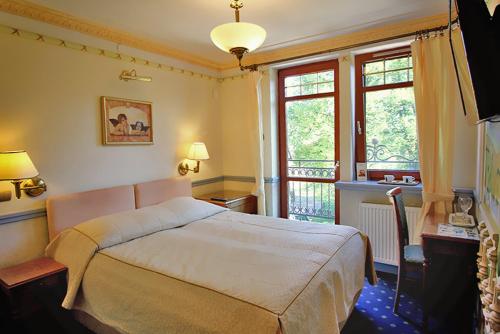 库瑞尼卡慕斯卡威拉阿莫尔旅馆的一间带大床的卧室和一个阳台