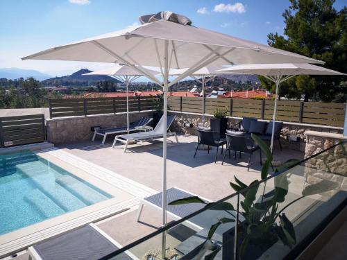 纳夫普利翁Andrew's Luxury Residence的白色遮阳伞和椅子以及游泳池