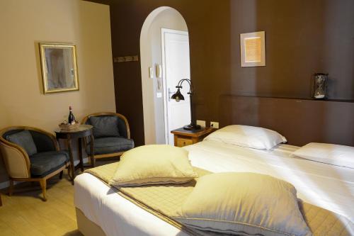 加尔多内-里维耶拉Washington Apartments al Vittoriale的酒店客房,配有两张床和两把椅子