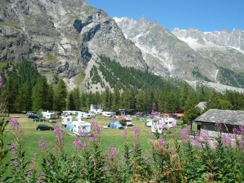 库马约尔Camping Aiguille Noire的山前田野上的一组帐篷