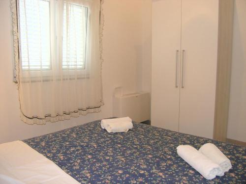 克尔克Apartments Sokolović的一间卧室配有一张床,上面有两条毛巾