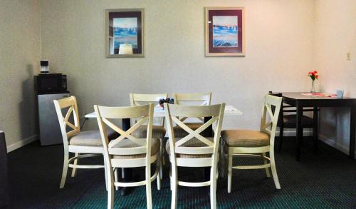 威尔明顿Azalea Inn & Suites的用餐室配有桌椅、桌子和桌椅