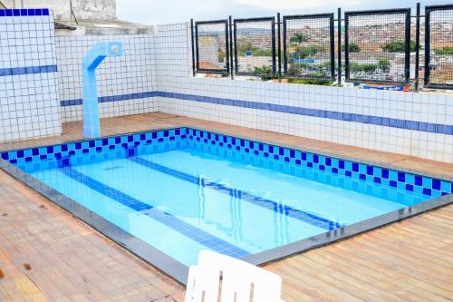 卡鲁阿鲁Center Plaza Hotel的一座大型游泳池,位于大楼内,铺有蓝色瓷砖