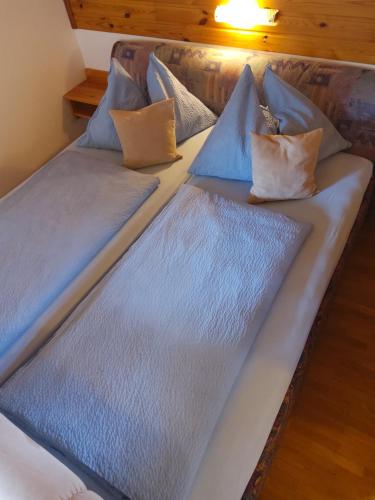 ArriachLandhaus Unterköfler的一张带蓝色床单和枕头的床
