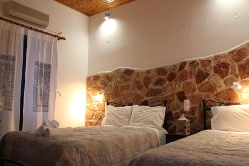弗纳瑞亚Tentes Holiday Homes的一间卧室设有两张床和石墙