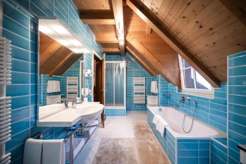 奥蒂塞伊斯特拉公寓别墅酒店的蓝色的浴室设有两个盥洗盆和一个浴缸。