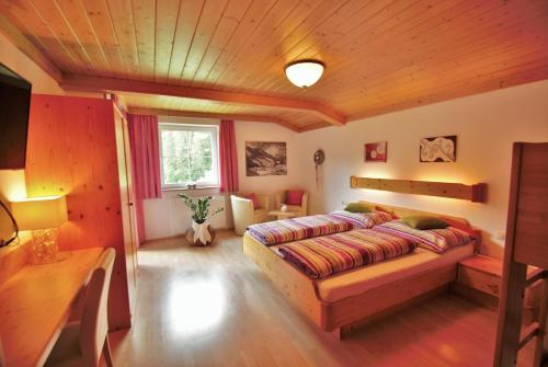 萨尔巴赫里佩尔公寓的一间卧室设有一张床和木制天花板