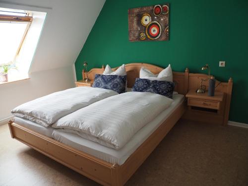 Nahrendorf梅耶旅馆的一间卧室设有一张大床和绿色的墙壁