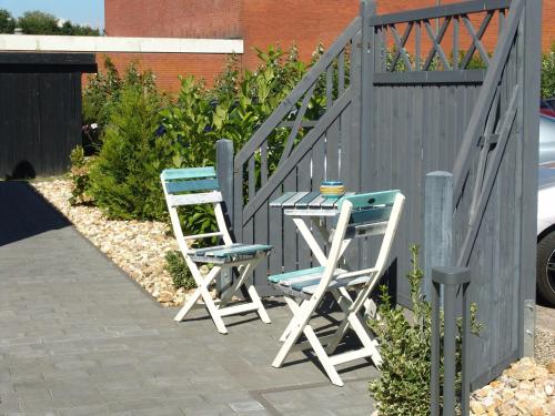 比苏姆Haus-Norderpiep的围栏旁的两把椅子和一张桌子