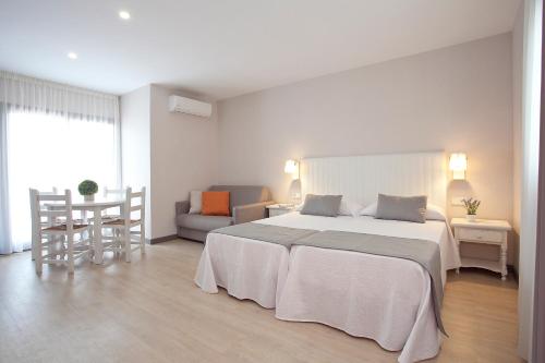 贝尼多姆Apartamentos Ribera的白色卧室设有一张大床和一张沙发
