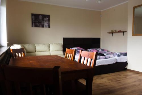 韦巴Apartamenty Wilk的客厅配有桌子、沙发和床。
