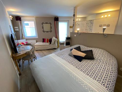 莱斯坎Studio rez-de-chaussée, à Lesquin/Lille aéroport的一间卧室配有一张床铺和一张桌子,另一间卧室配有一张桌子。