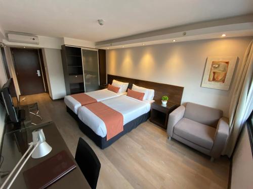 蒙得维的亚水晶塔酒店的配有一张床和一把椅子的酒店客房