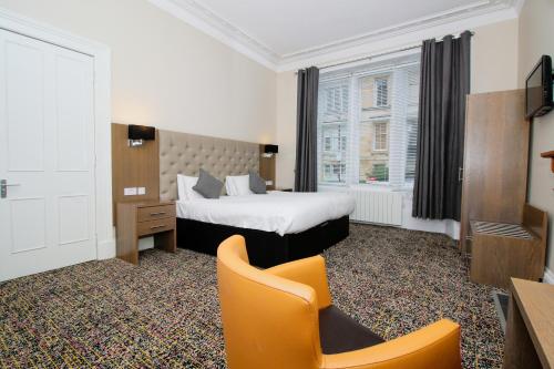 格拉斯哥City Apartments的配有一张床和一把椅子的酒店客房