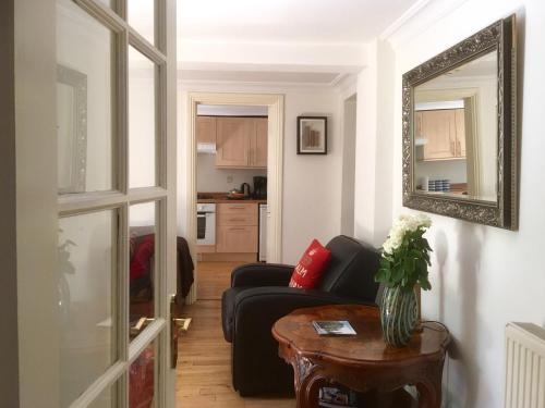 伦敦Griffin House Holiday Apartments的客厅配有黑色沙发和镜子