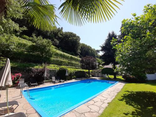 梅拉诺西特讷霍夫农庄酒店的一座树木繁茂的庭院内的游泳池