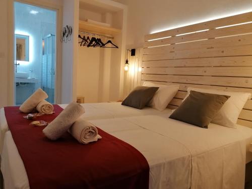 卡利诺岛Afrodite Luxury Rooms的一间卧室配有一张大床和毛巾