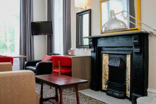 格拉斯哥阿尔比欧酒店的客厅设有壁炉和红椅
