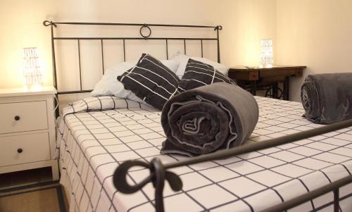费拉约港Agriturismo dei girasoli的一张带黑白枕头的床和一顶帽子