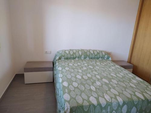 阿尔么丽亚COSTA DE ALMERIA PLAYA的一间小卧室,配有一张带绿色棉被的床