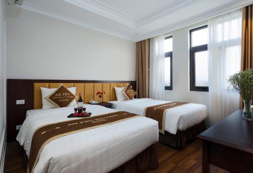 下龙湾An Phu Ha Long Villa的酒店客房设有两张床和窗户。