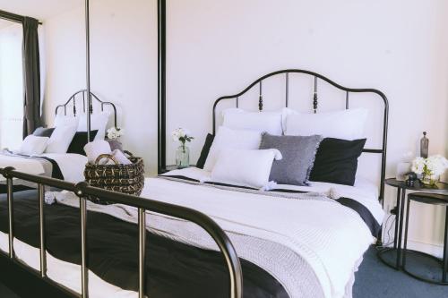 堪培拉Capitol Executive Apartment on London Circuit的一间卧室配有两张带白色和灰色枕头的床。