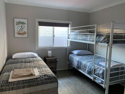 苏塞克斯入口拉古那假日公园的一间卧室设有两张双层床和一扇窗户。